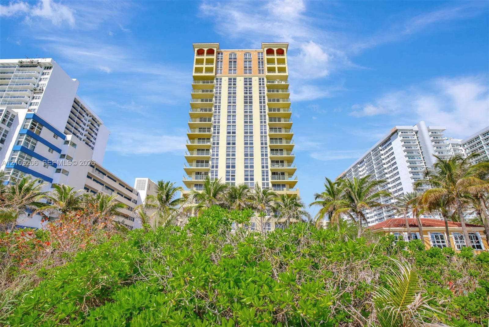 2080 S Ocean Drive, #112, Hallandale Beach, Hallandale Beach, FL 33009 High-rise residential building featuring stacked private balconies, arched architectural detailing, and lush coastal landscaping