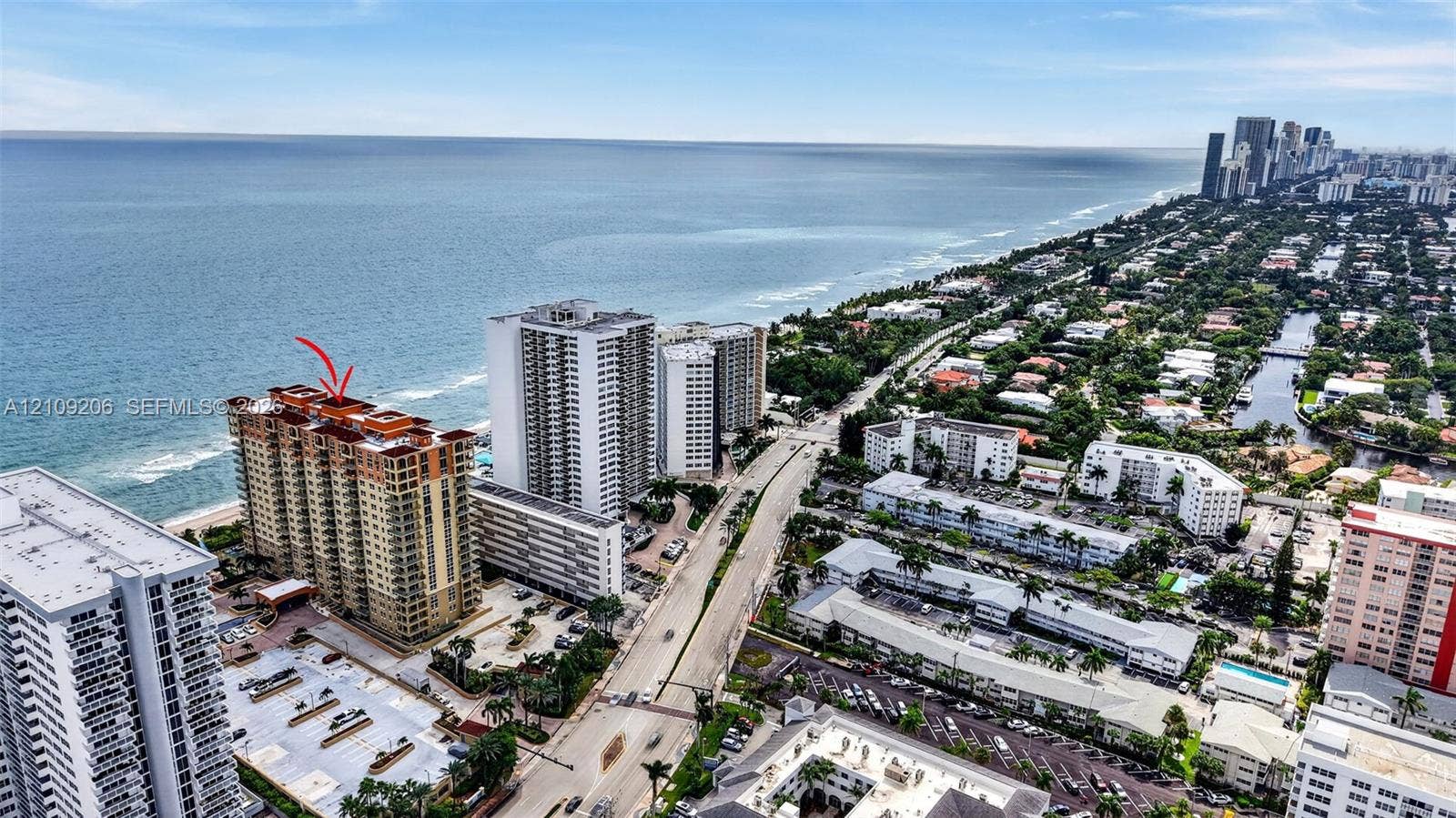 2080 S Ocean Drive, #112, Hallandale Beach, Hallandale Beach, FL 33009 High-rise coastal building featuring a terracotta-tiled roof, private balconies, and immediate proximity to the oceanfront
