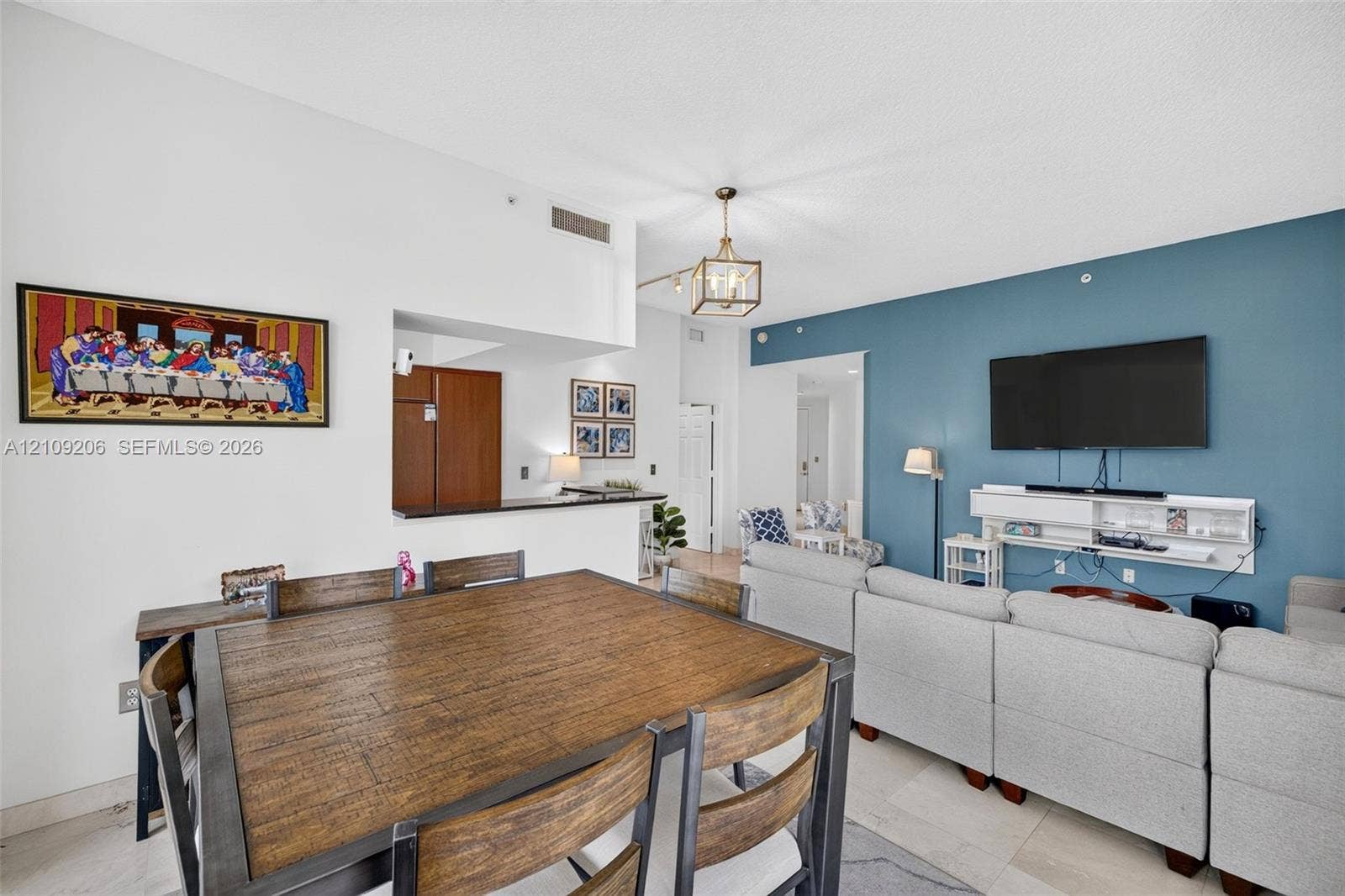 2080 S Ocean Drive, #112, Hallandale Beach, Hallandale Beach, FL 33009 Open-concept interior featuring a high ceiling, accent wall, polished tile flooring, pendant lighting, and a breakfast bar