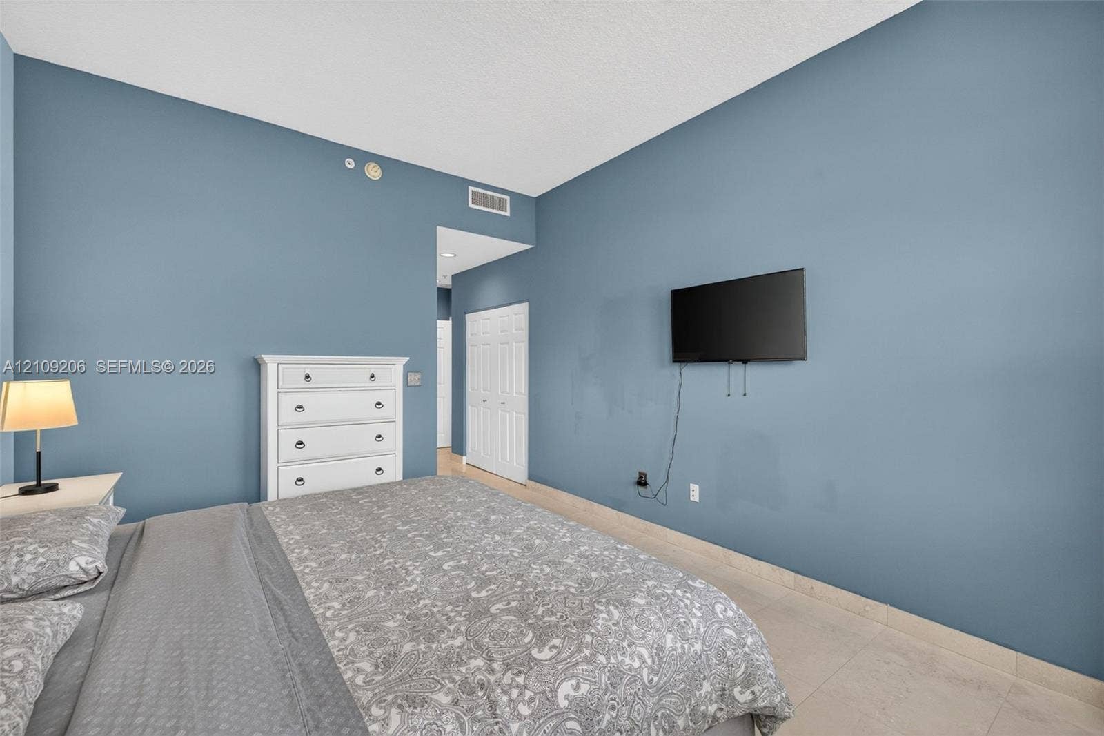 2080 S Ocean Drive, #112, Hallandale Beach, Hallandale Beach, FL 33009 Room featuring blue painted walls, neutral stone-finish flooring, and white bifold closet doors
