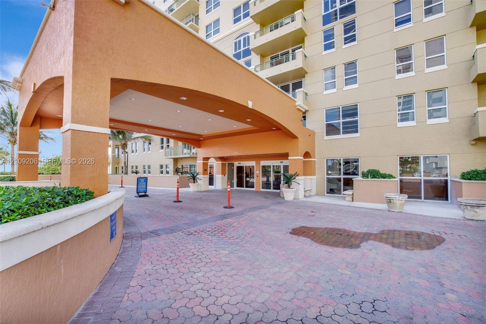 2080 S Ocean Drive, #112, Hallandale Beach, Hallandale Beach, FL 33009 Covered porte-cochre entry featuring arched architectural detailing, recessed lighting, and a paved brick driveway