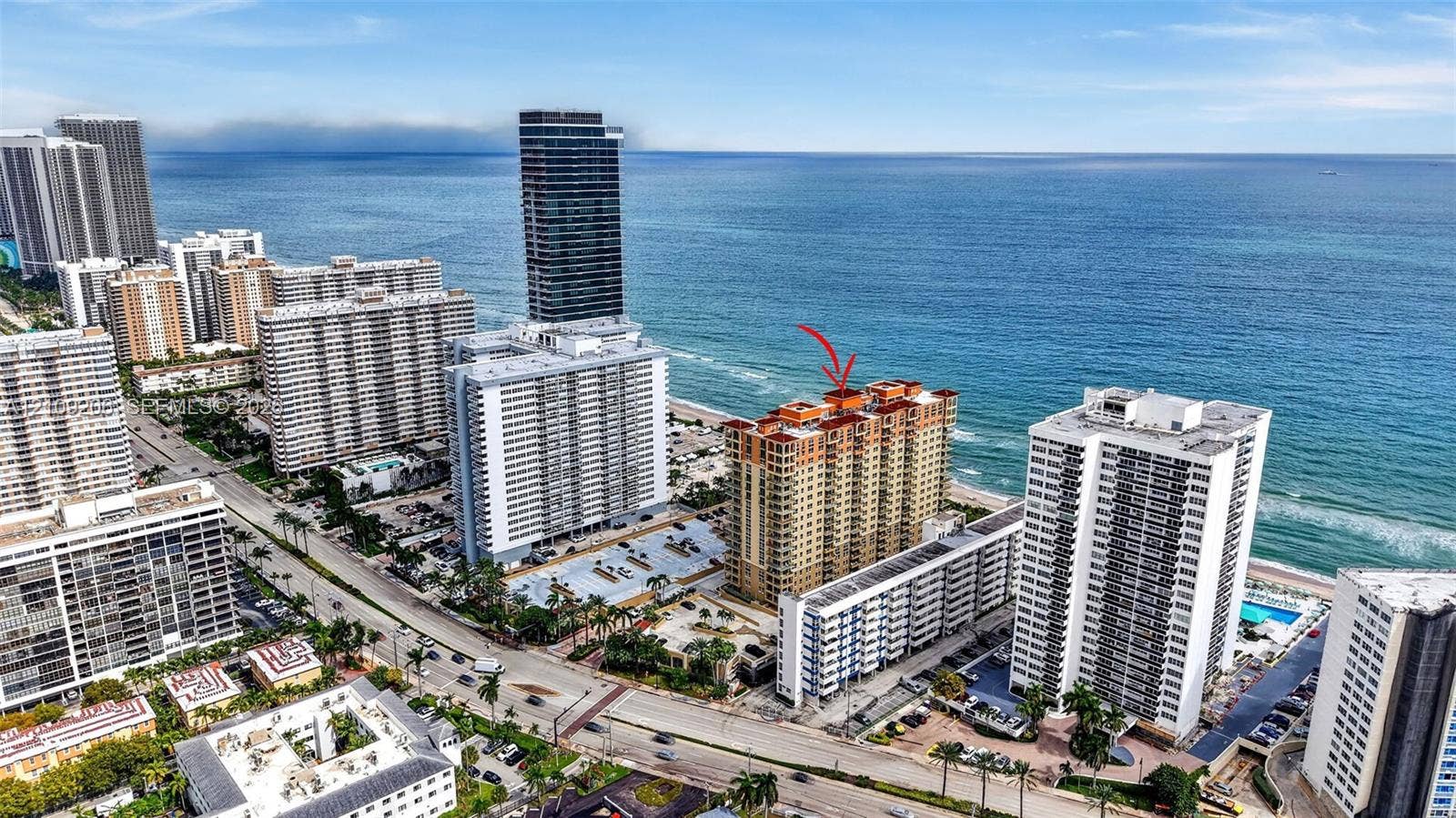 2080 S Ocean Drive, #112, Hallandale Beach, Hallandale Beach, FL 33009 High-rise residential building featuring a terracotta-tiled roof and immediate coastal proximity to the Atlantic Ocean