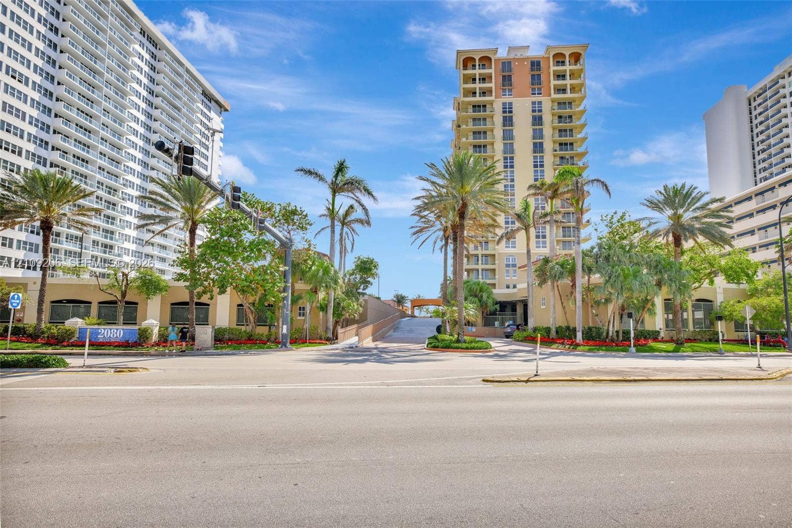 2080 S Ocean Drive, #112, Hallandale Beach, Hallandale Beach, FL 33009 High-rise residential tower featuring arched architectural detailing, private balconies, a multi-story facade, and mature palm tree landscaping