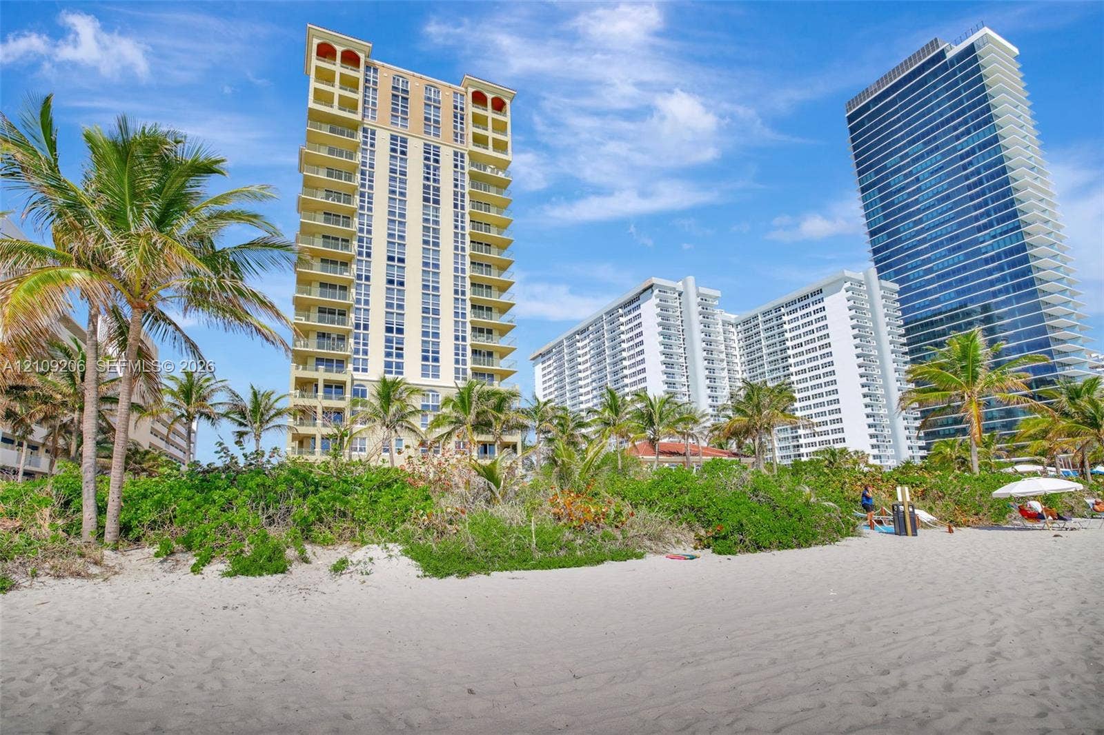 2080 S Ocean Drive, #112, Hallandale Beach, Hallandale Beach, FL 33009 High-rise building featuring private balconies, expansive sand beach access, and mature palm landscaping