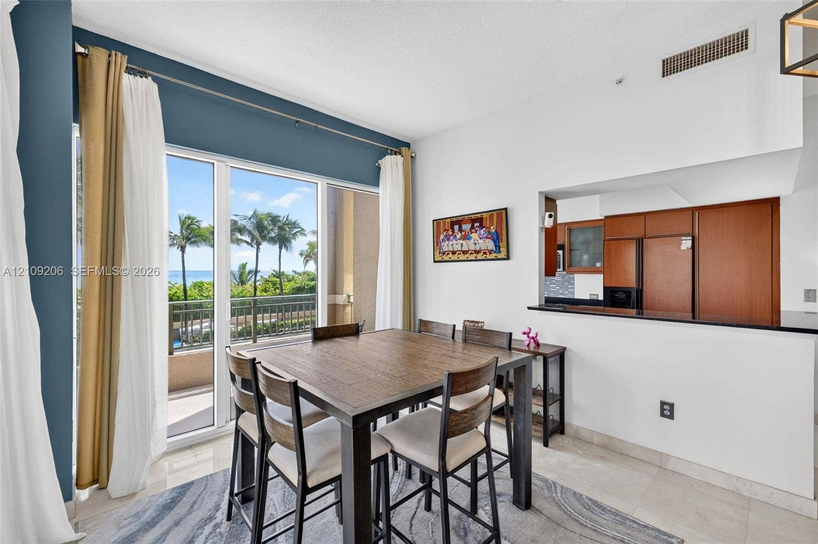 2080 S Ocean Drive, #112, Hallandale Beach, Hallandale Beach, FL 33009 Floor-to-ceiling glass sliding doors with balcony access, kitchen pass-through window with black stone countertop, and tile flooring