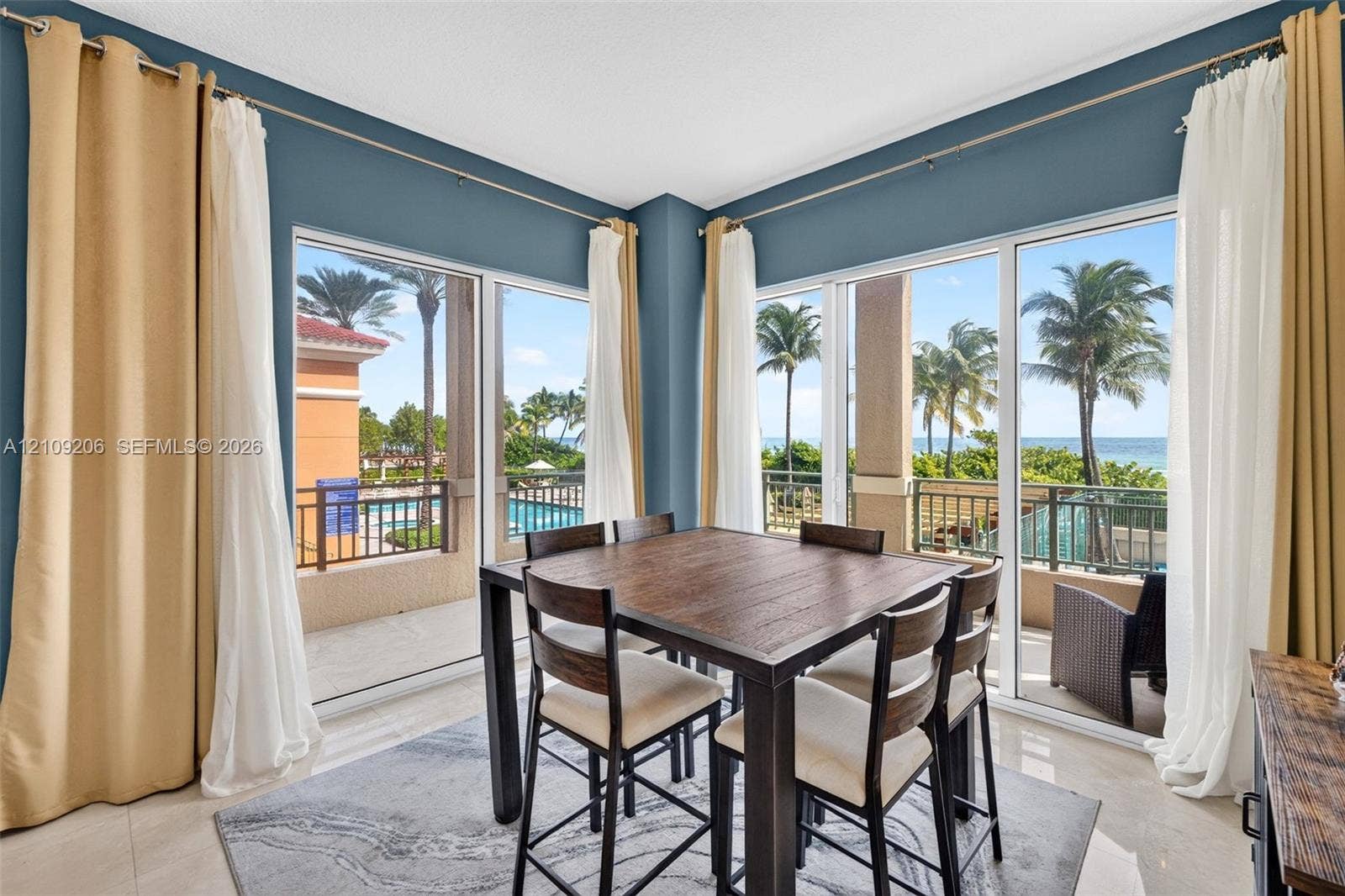 2080 S Ocean Drive, #112, Hallandale Beach, Hallandale Beach, FL 33009 Corner dining space featuring floor-to-ceiling glass sliding doors, neutral tile flooring, and coastal water backdrop
