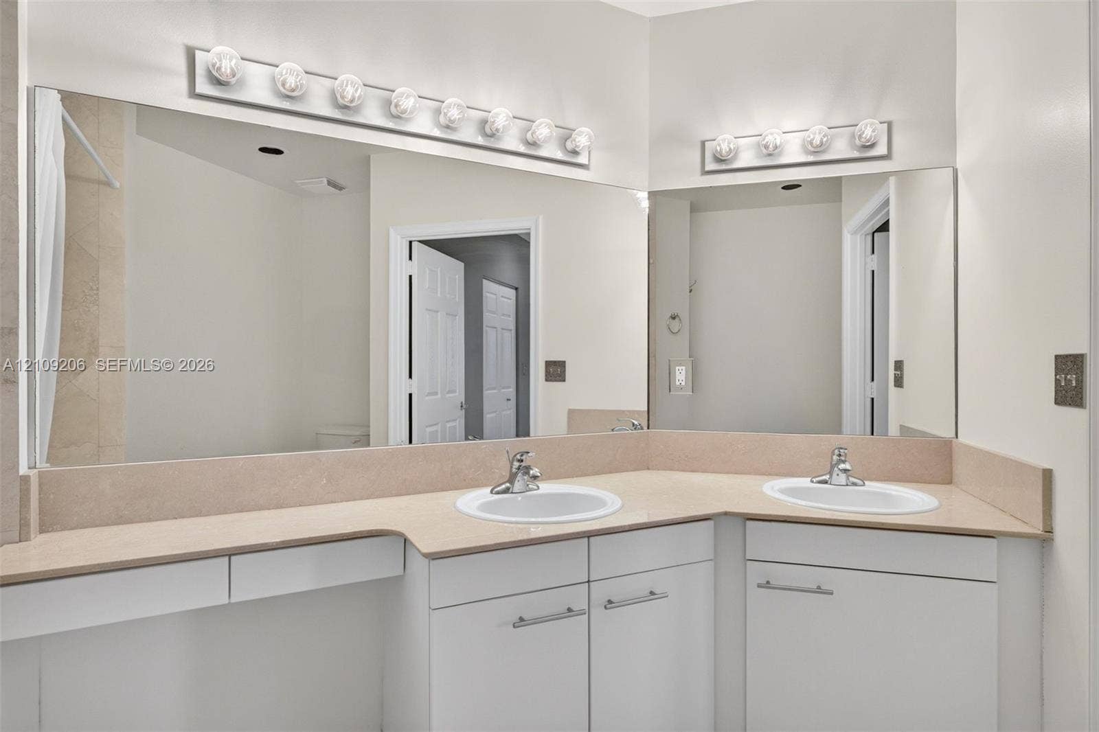 2080 S Ocean Drive, #112, Hallandale Beach, Hallandale Beach, FL 33009 Dual-basin vanity featuring white cabinetry, solid-surface countertop, integrated backsplashes, and wall-mounted light fixtures