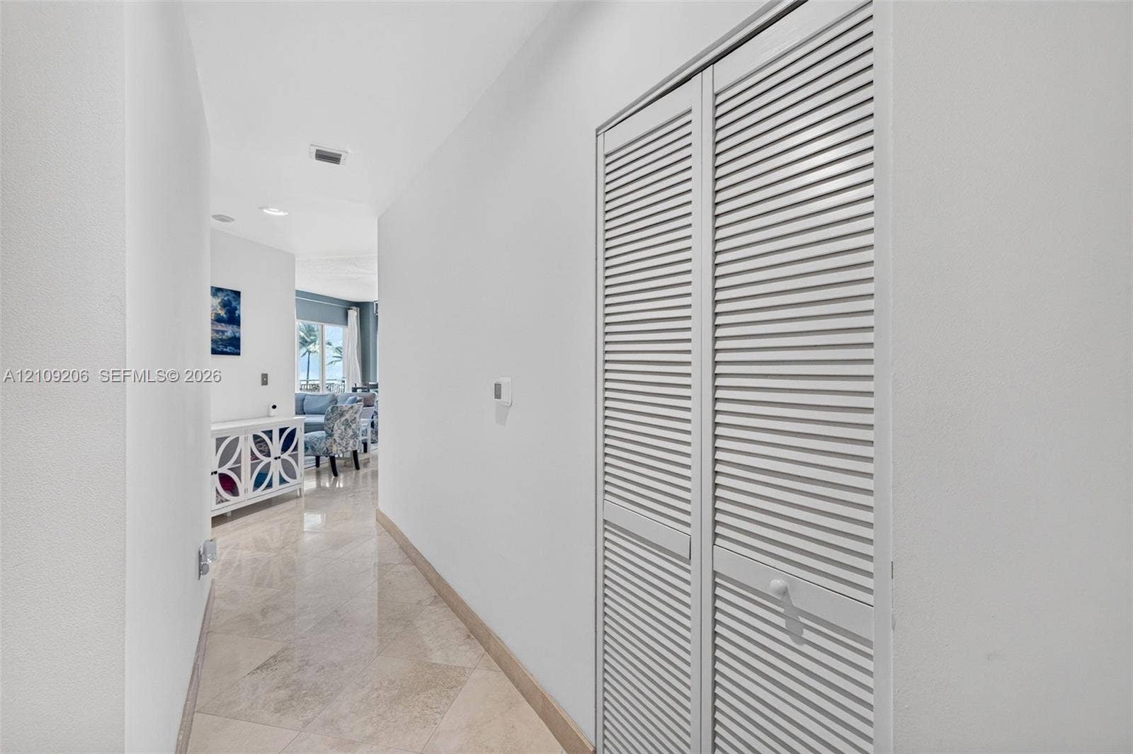 2080 S Ocean Drive, #112, Hallandale Beach, Hallandale Beach, FL 33009 Hallway featuring light-toned stone tile flooring and dual louvered closet doors
