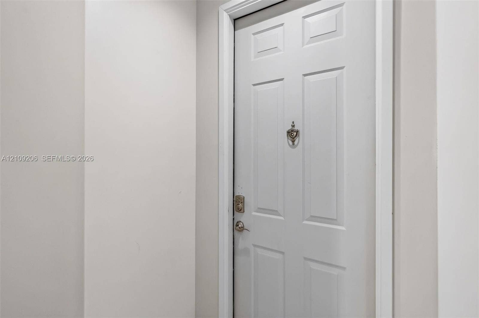 2080 S Ocean Drive, #112, Hallandale Beach, Hallandale Beach, FL 33009 Six-panel interior door featuring a metallic knocker, deadbolt lock, and matching lever handle