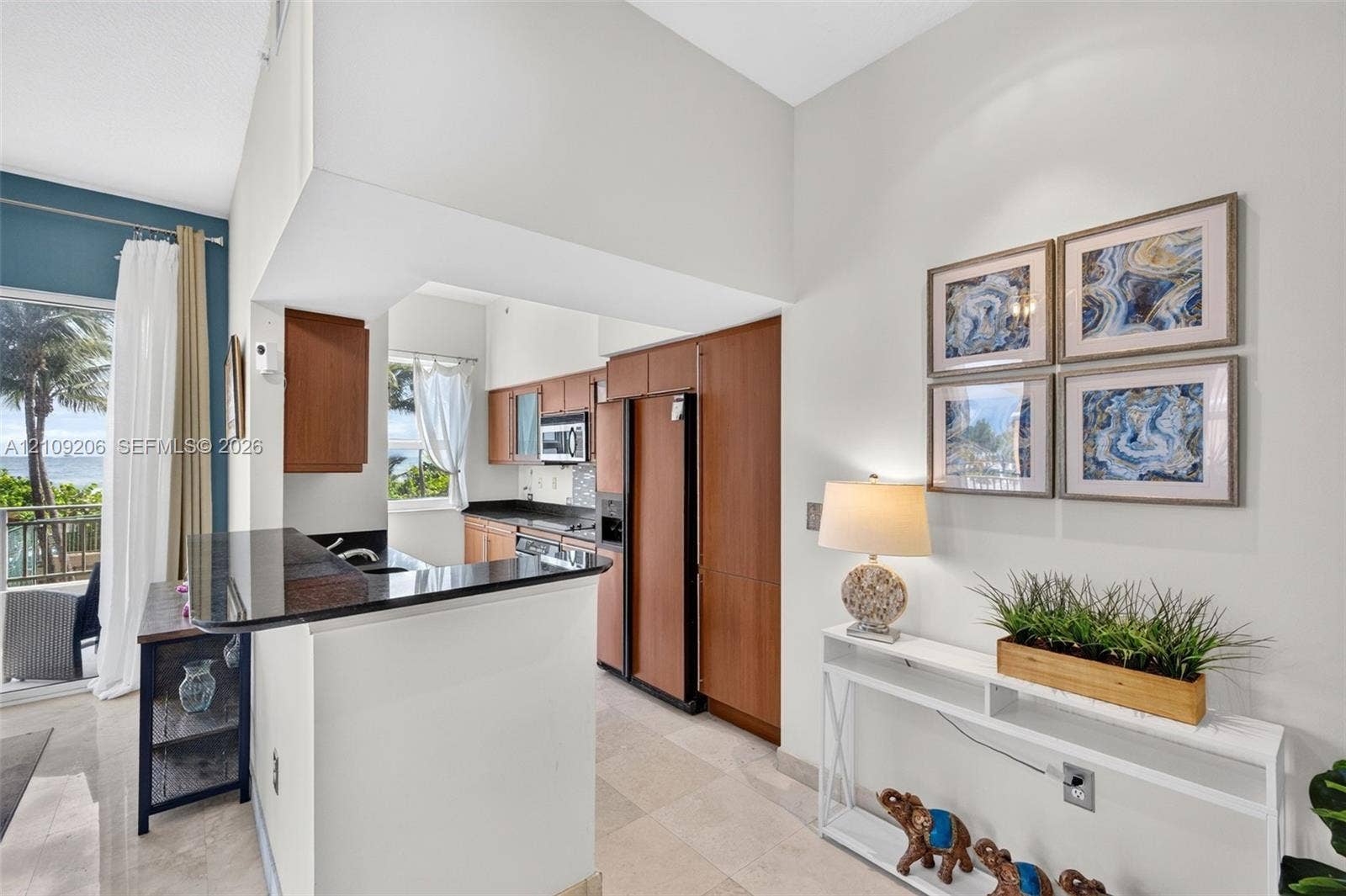 2080 S Ocean Drive, #112, Hallandale Beach, Hallandale Beach, FL 33009 Kitchen featuring wood-finish cabinetry, stone countertops, a breakfast bar, and tile flooring