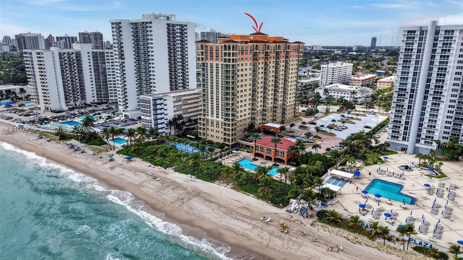 2080 S Ocean Drive, #112, Hallandale Beach, Hallandale Beach, FL 33009 High-rise oceanfront building featuring a tile roof, exterior balconies, a ground-level swimming pool, and direct beach access