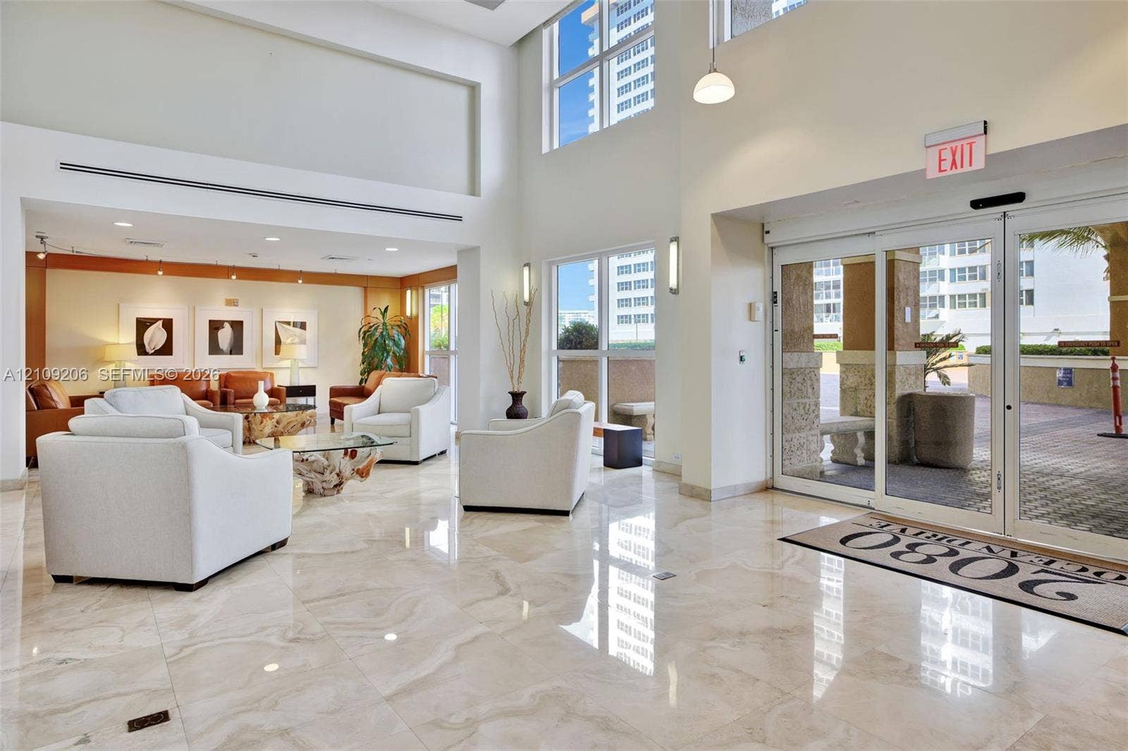 2080 S Ocean Drive, #112, Hallandale Beach, Hallandale Beach, FL 33009 Grand lobby entrance featuring high-gloss stone flooring, floor-to-ceiling windows, double-height ceilings, and automatic glass sliding entry doors