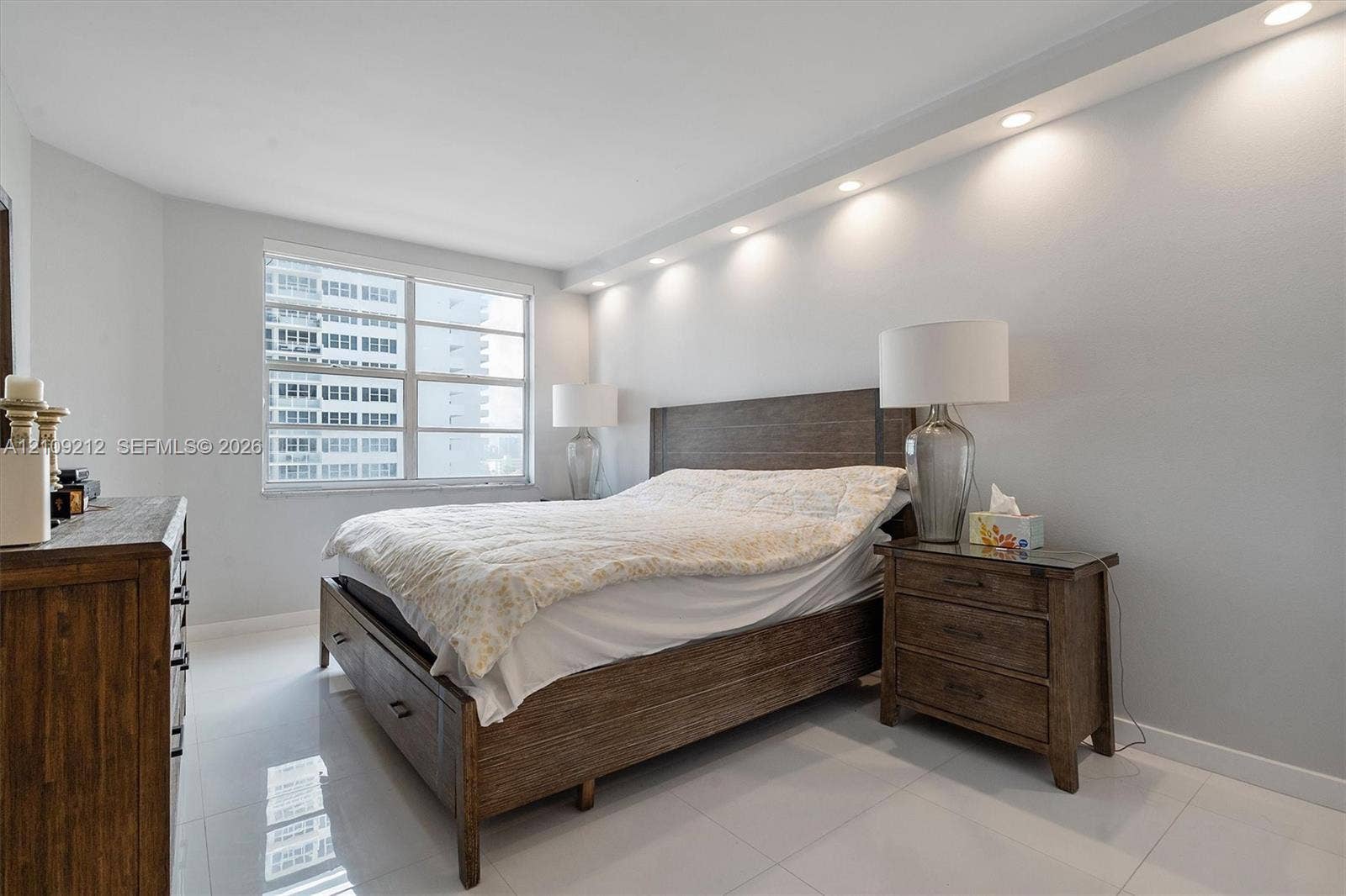 Large multi-pane window, recessed lighting, and white tile flooring