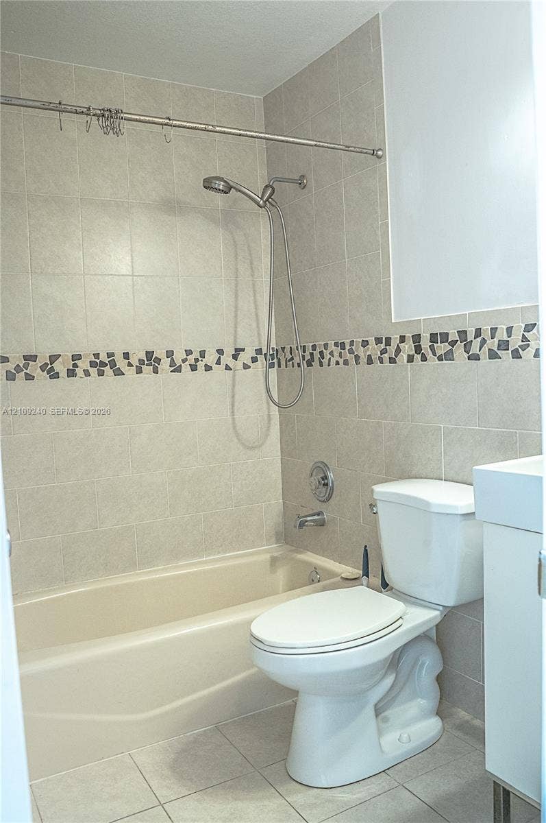 21115 SW 125th Ct Road, Miami, Miami, FL 33177 Full bathtub with integrated showerhead, neutral ceramic wall tile, decorative mosaic tile inlay, and floor tiling