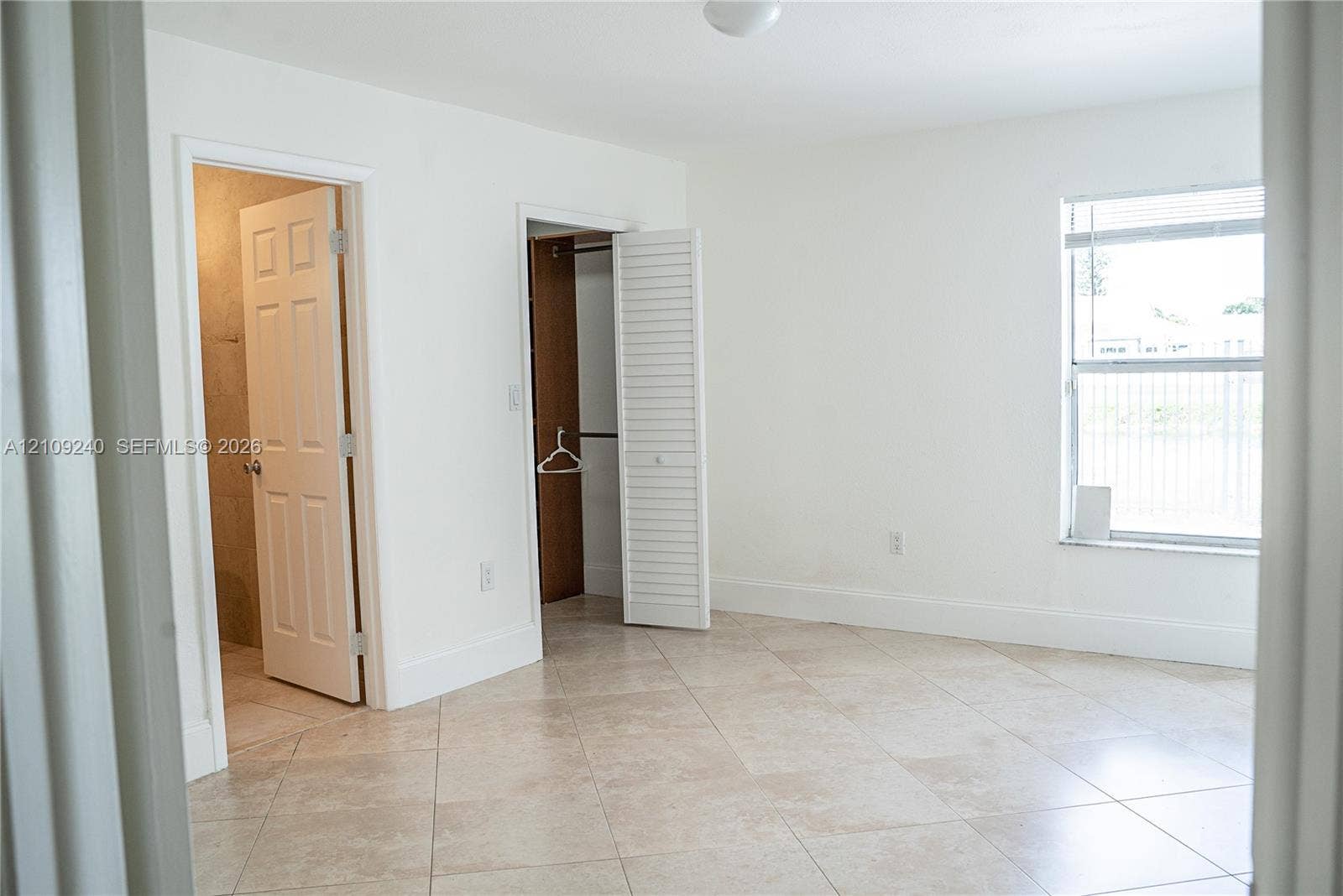 21115 SW 125th Ct Road, Miami, Miami, FL 33177 Neutral-toned ceramic tile flooring, interior closet with louvered doors, and a single-hung window with white frame