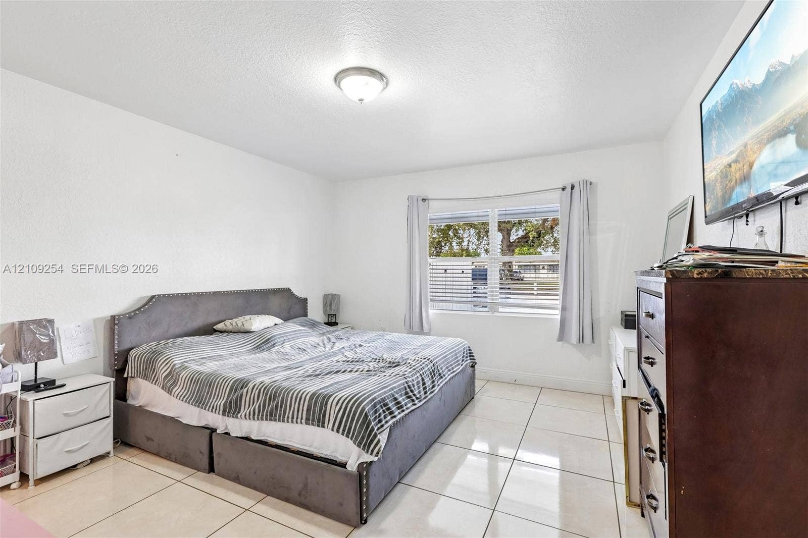 21342 NW 40th Cir Court, Miami Gardens, FL 33055 Spacious room featuring large-format tile flooring, smooth-finish walls, and a multi-pane window with natural light