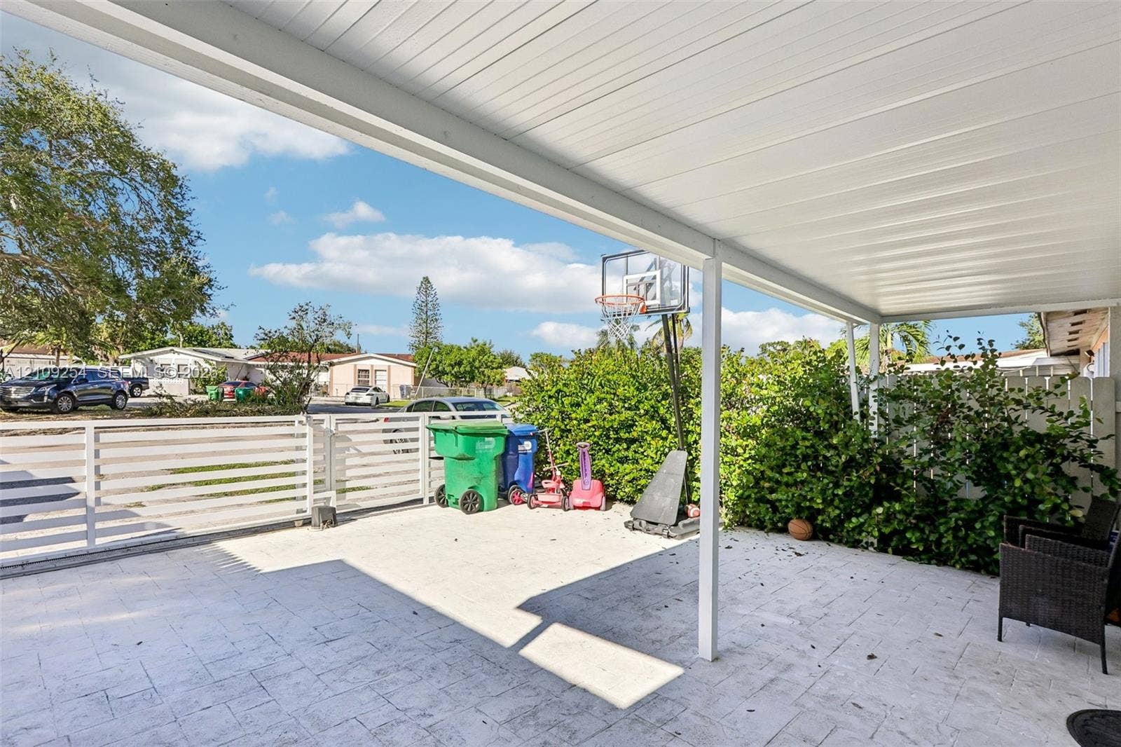21342 NW 40th Cir Court, Miami Gardens, FL 33055 Covered patio featuring a paved floor, a white metal ceiling, and a white horizontal slat fence