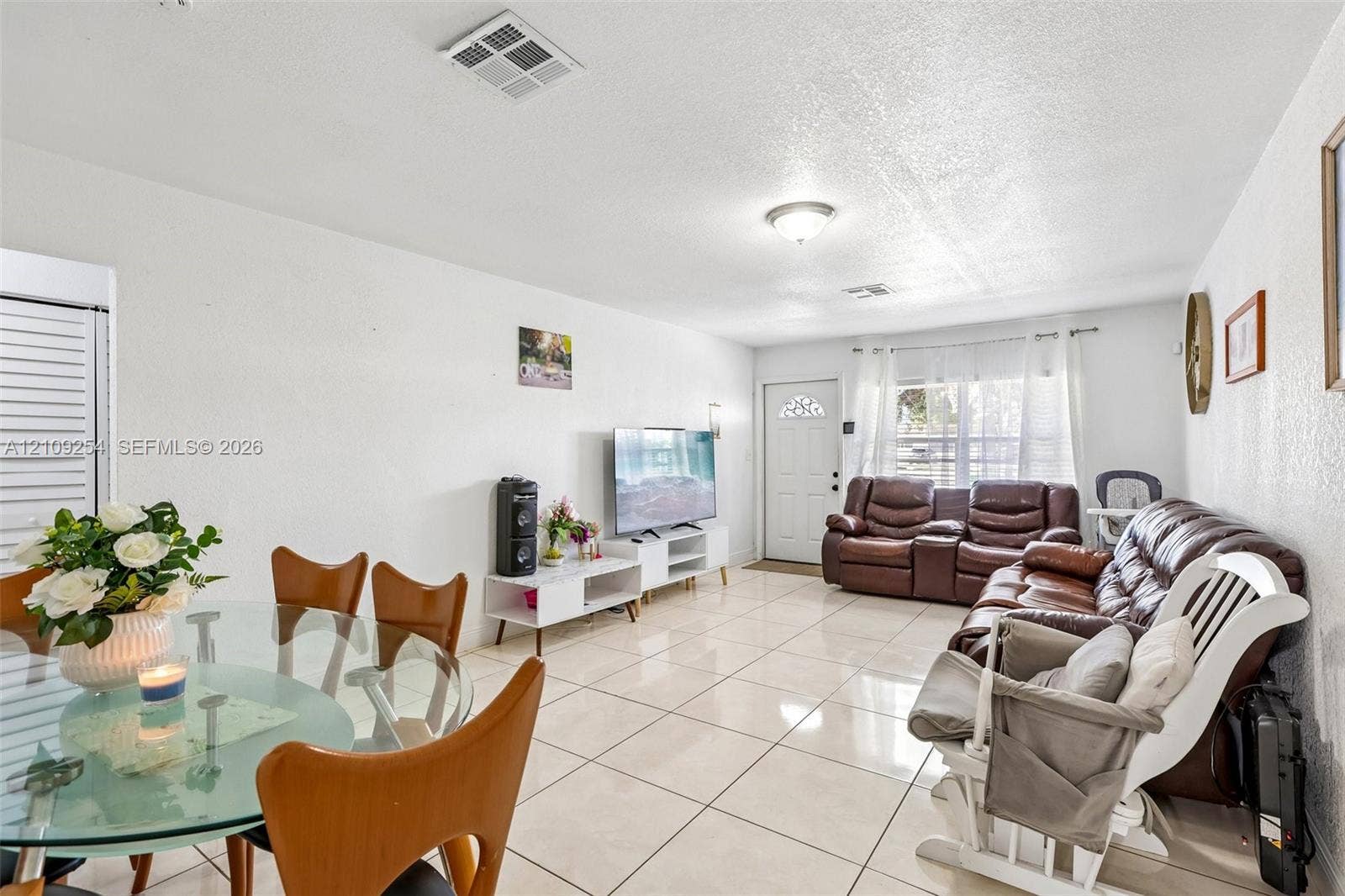 21342 NW 40th Cir Court, Miami Gardens, FL 33055 Open floor plan featuring large-format ceramic tile flooring, neutral wall finishes, a flush-mount ceiling light fixture, and a window with white casing