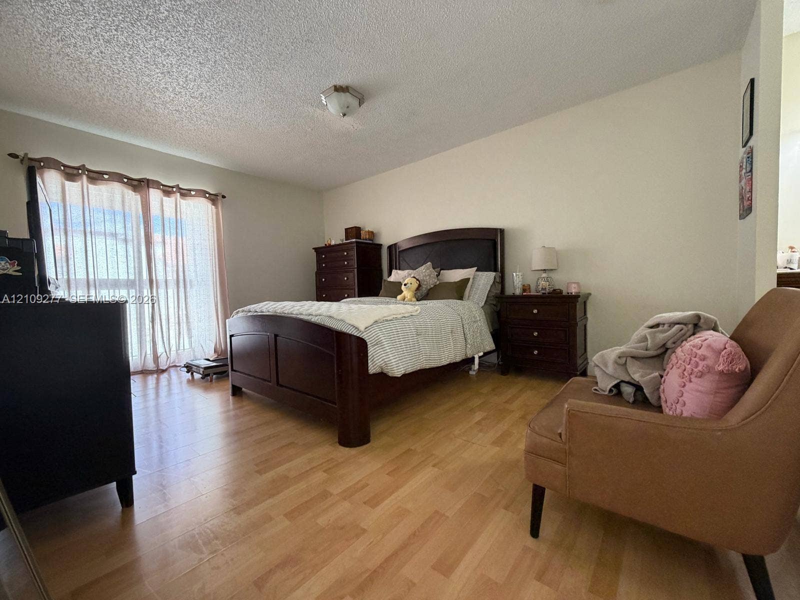 Wood-finish flooring, sliding glass door, and flush-mount ceiling lighting