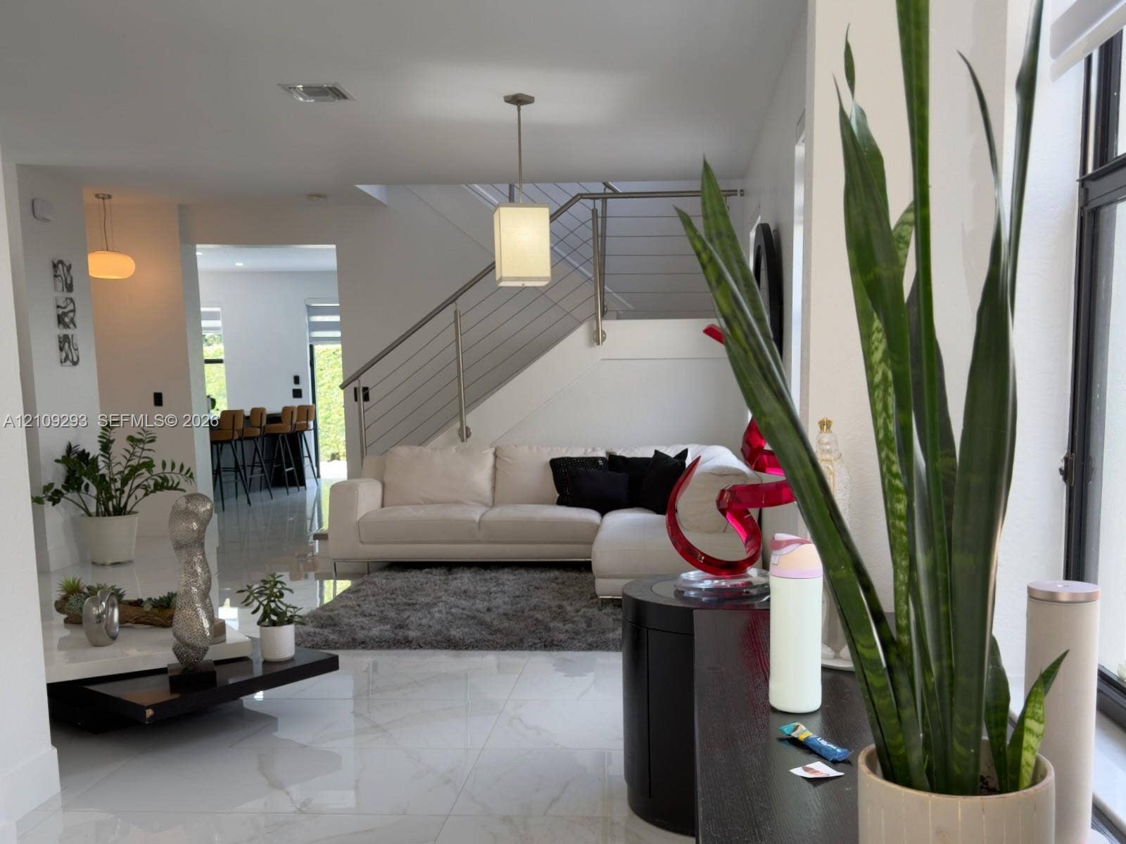 8880 NW 115th Court, Doral, FL 33178 Interior featuring large-format tile flooring, a staircase with cable railings, recessed lighting, and a pendant light fixture