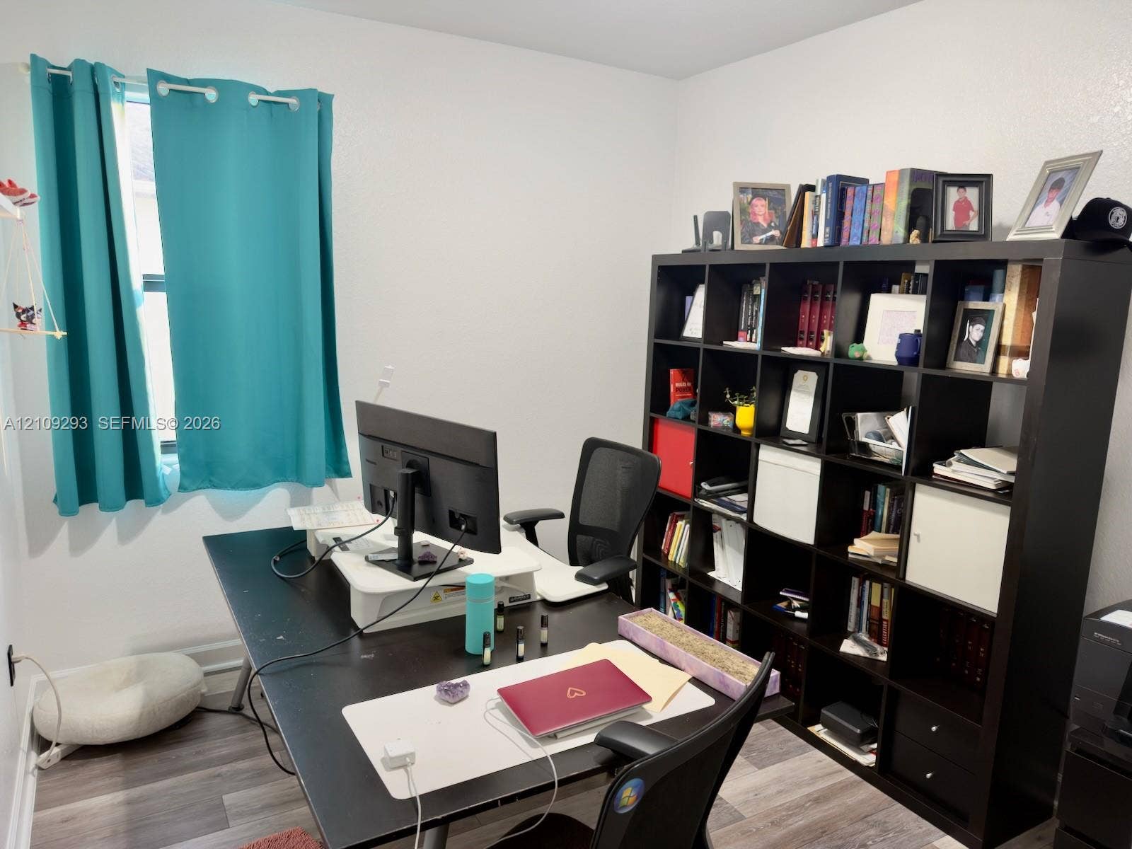 8880 NW 115th Court, Doral, FL 33178 Neutral-toned walls paired with wood-finish flooring and a single-pane window
