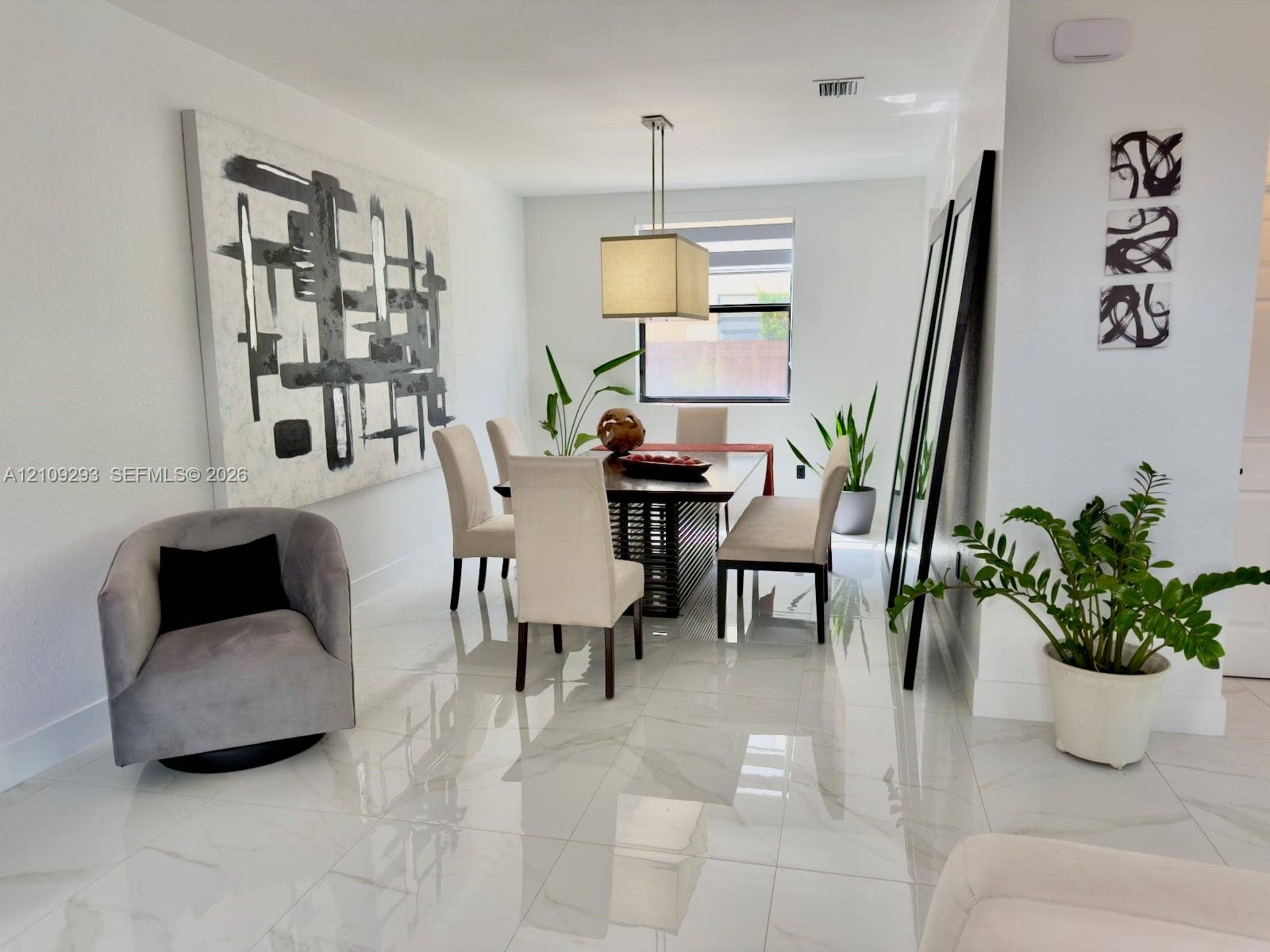 8880 NW 115th Court, Doral, FL 33178 Neutral-toned interior space featuring polished large-format tile flooring and a suspended rectangular pendant light fixture