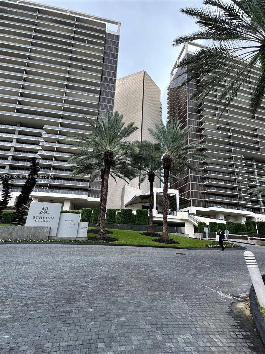 9703 Collins Avenue, #400, Bal Harbour, FL 33154 High-rise architectural exterior featuring glass-railed private balconies, paved motor court, mature palm trees, and manicured landscaping