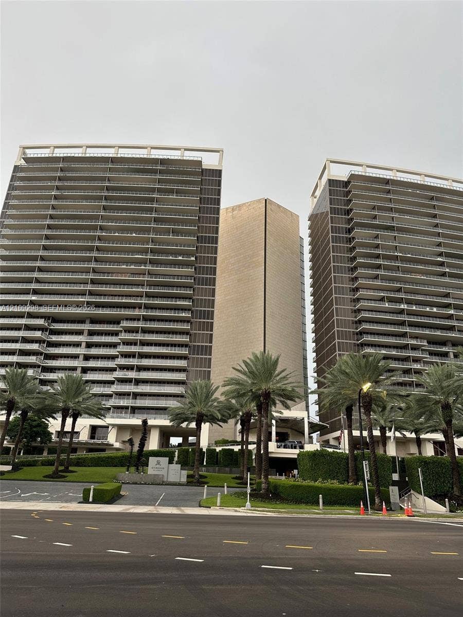 9703 Collins Avenue, #400, Bal Harbour, FL 33154 Twin high-rise towers featuring glass-paneled balconies, floor-to-ceiling windows, and manicured landscaping with mature palms