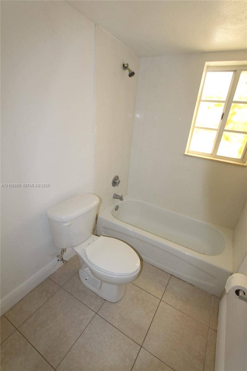 4810 NW 79 Avenue, #107, Doral, Doral, FL 33166 Bathroom featuring ceramic tile flooring, white porcelain tub and shower combination, polished metal fixtures, and a dual-pane window