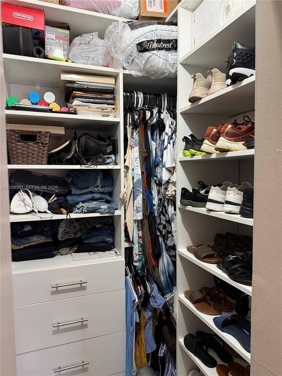 7680 SW 153rd Court, #204, Miami, Miami, FL 33193 Custom closet organization system featuring white built-in shelving, multiple open storage compartments, and three lower drawers with metal hardware
