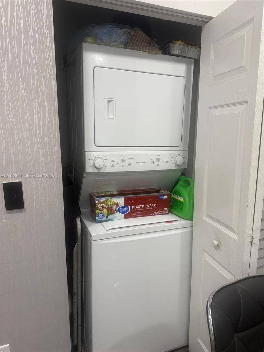 7680 SW 153rd Court, #204, Miami, Miami, FL 33193 Stacked laundry appliance configuration housed within a dedicated closet featuring a bi-fold door