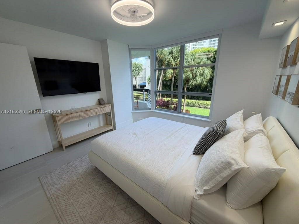Bay window with multi-pane glass, recessed ceiling lighting, circular flush-mount light fixture, and light-toned flooring