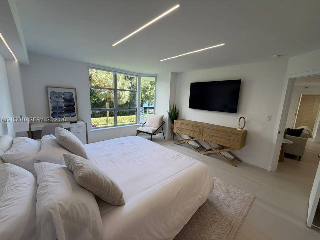 Neutral interior featuring recessed linear ceiling lighting, large-format tile flooring, and oversized windows