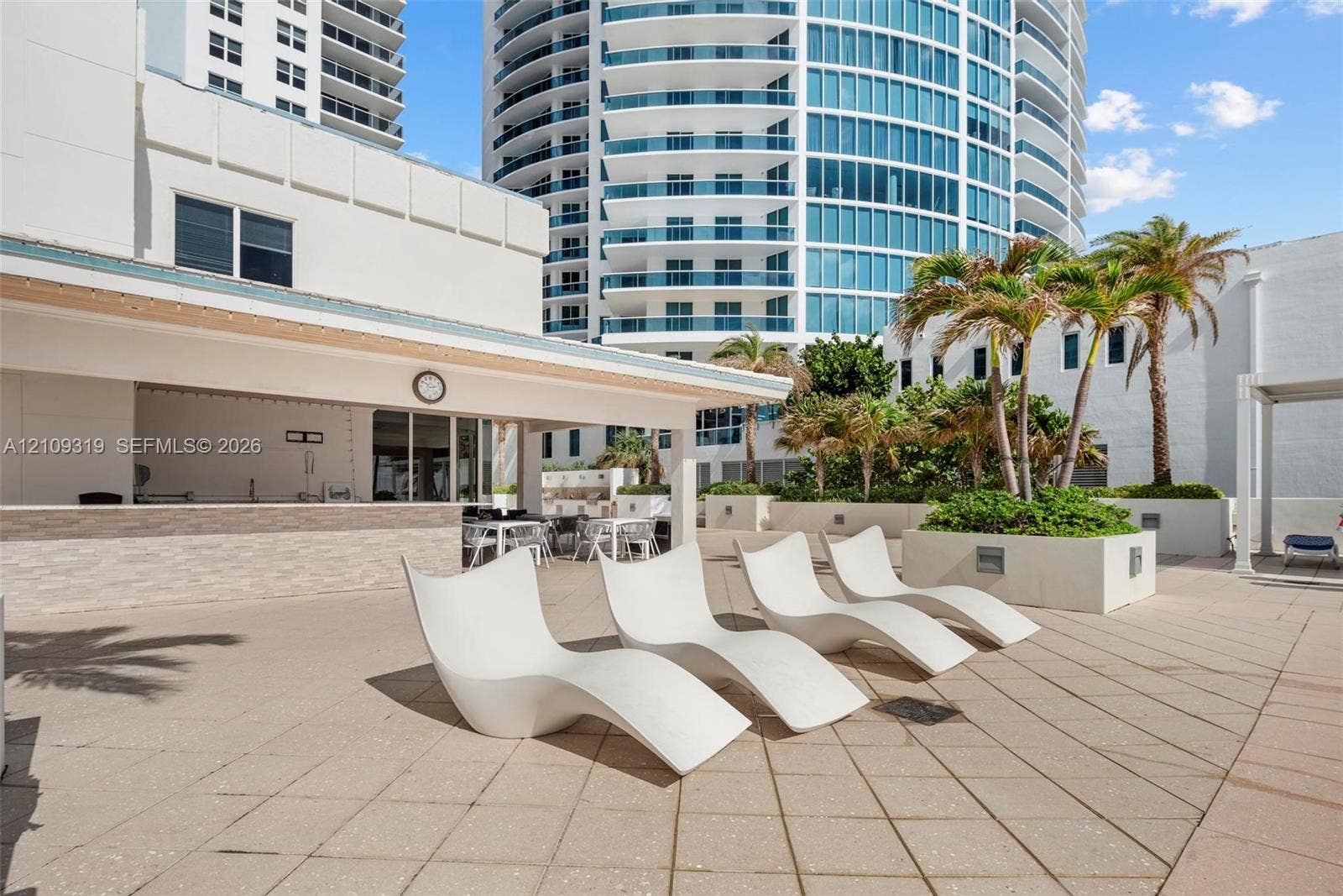 2751 S Ocean Drive, #1608N, Hollywood, FL 33019 Outdoor terrace featuring a covered bar area with stone-tile facade, concrete pavers, and integrated palm tree planters