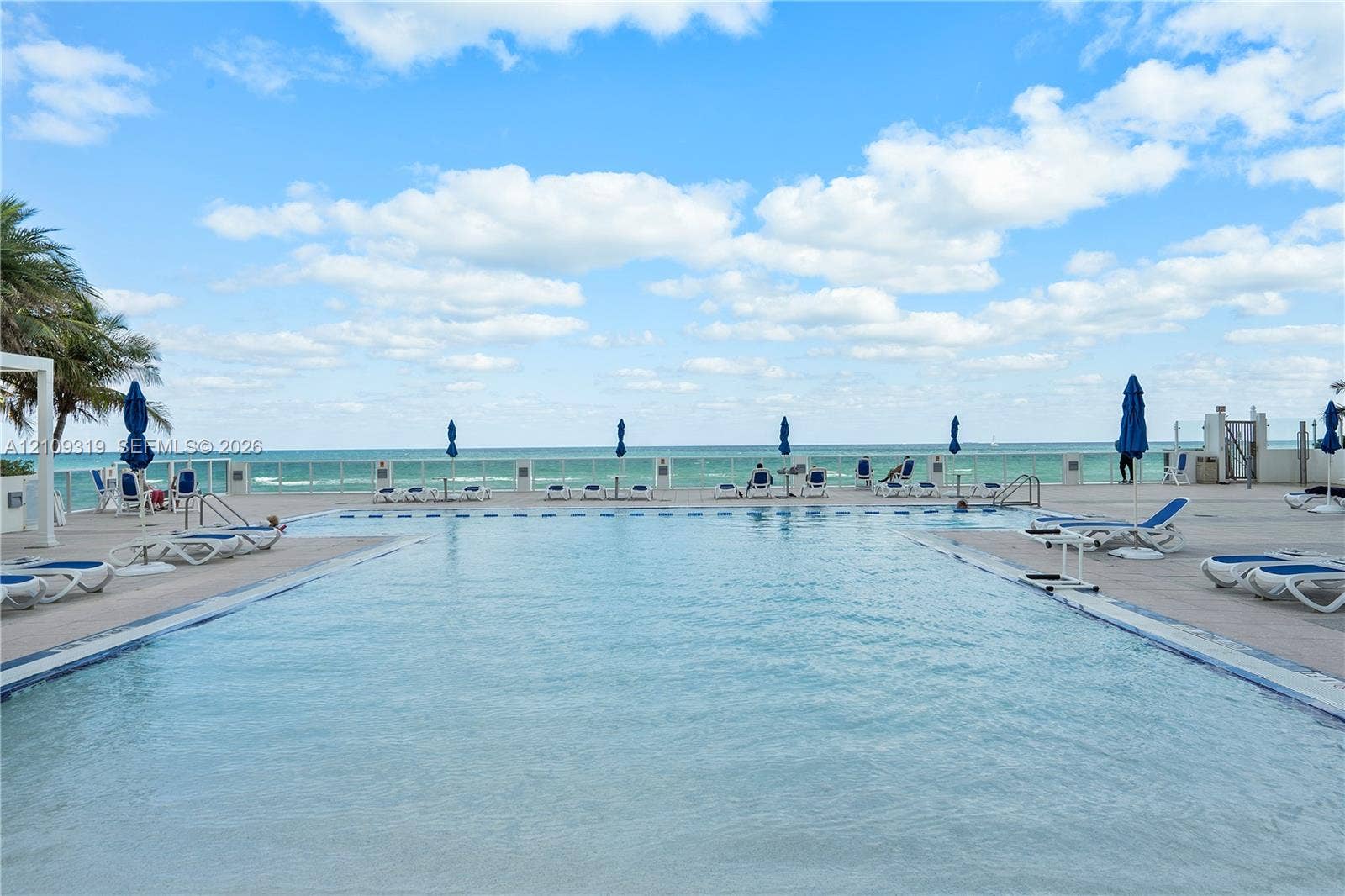 2751 S Ocean Drive, #1608N, Hollywood, FL 33019 Rectangular swimming pool featuring a tiled waterline, a shallow entry shelf, a surrounding paved pool deck, and a glass perimeter railing