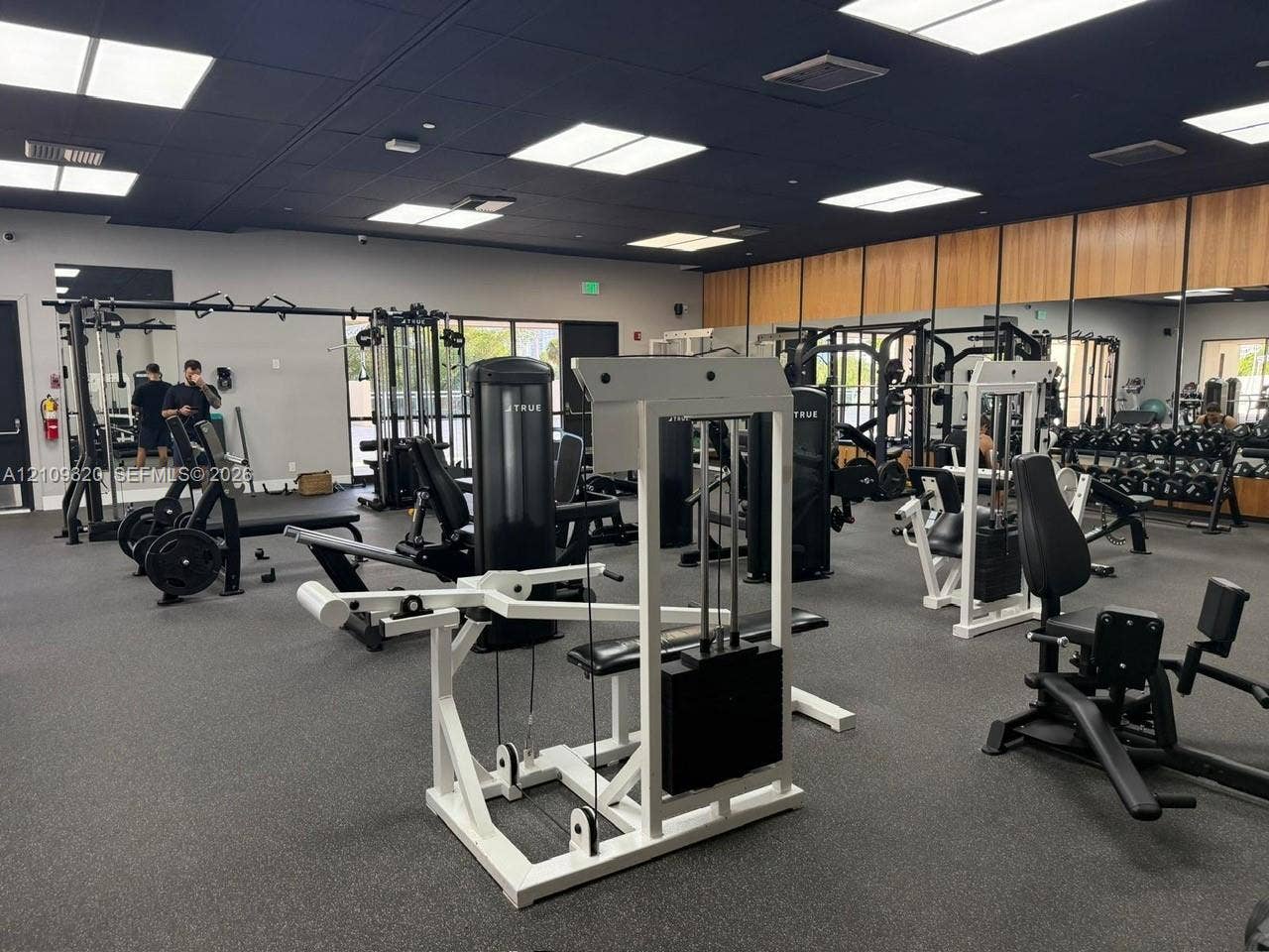 Fitness facility featuring rubberized flooring, ceiling-mounted lighting, and expansive floor-to-ceiling windows