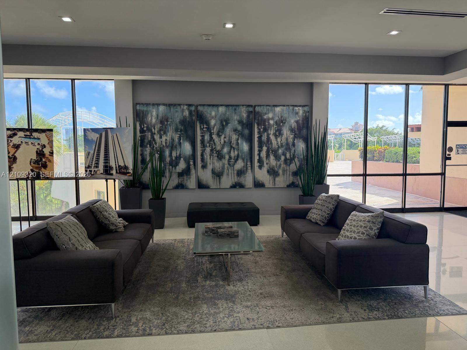 Elevator lobby featuring stone-clad wall accents, stainless steel elevator doors, recessed lighting, and polished flooring