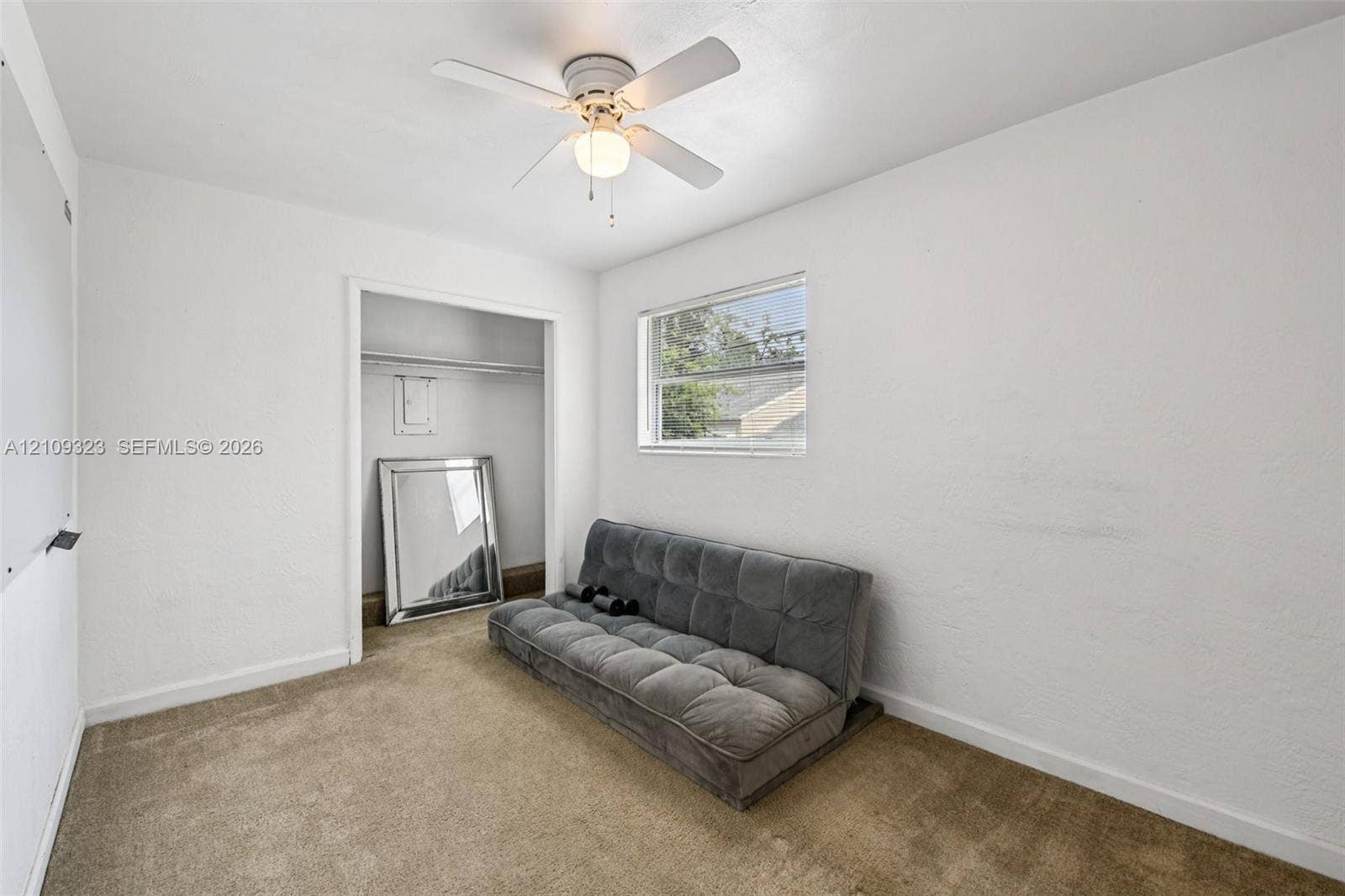 911 Shady Park Terrace, Daytona Beach, FL 32117 Neutral-toned carpeting, ceiling fan with integrated lighting, reach-in closet with built-in shelf, and a rectangular window