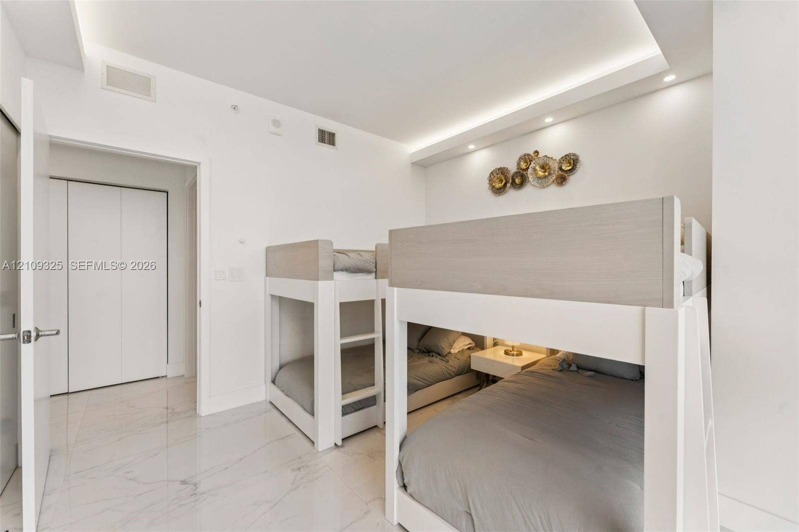 Interior space featuring polished stone-finish flooring, recessed tray ceiling lighting, and double-door closet storage