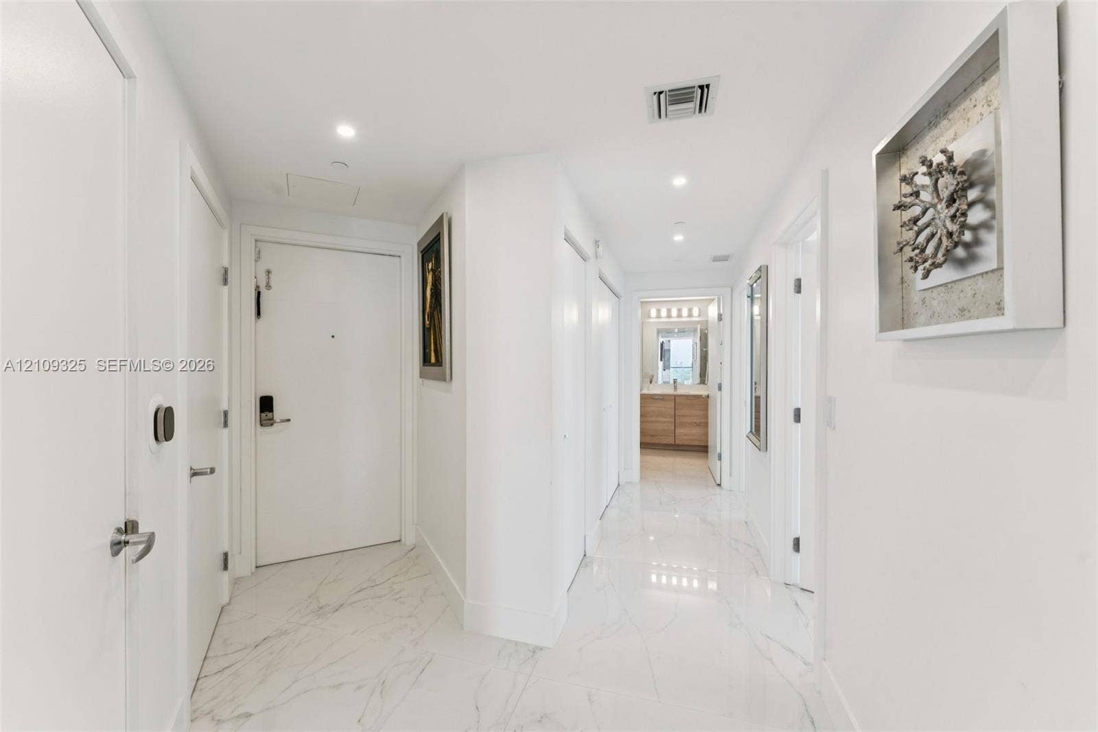 Entryway featuring polished stone-finish flooring, recessed lighting, and crisp white interior doors