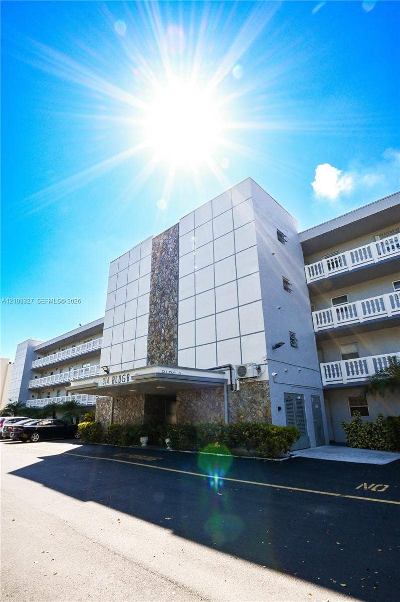 Multi-story exterior featuring panelized facade, natural stone cladding, and balconies