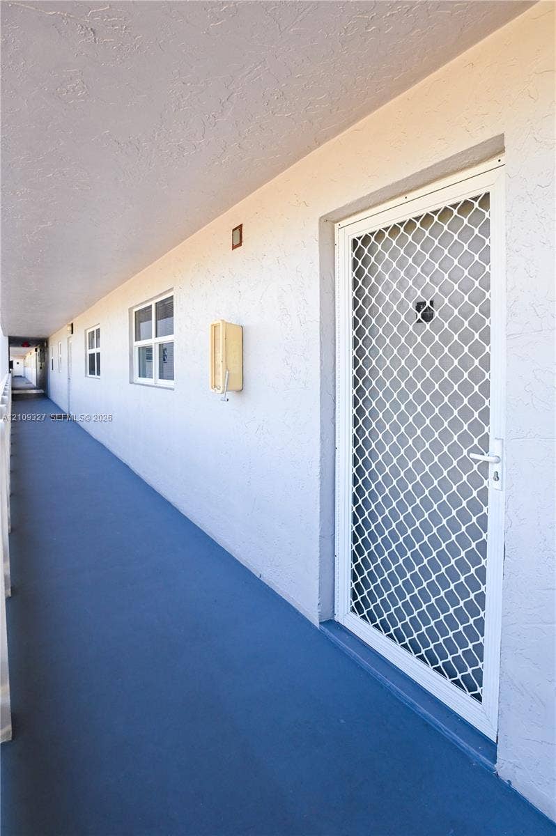 Exterior entry featuring a white metal security storm door