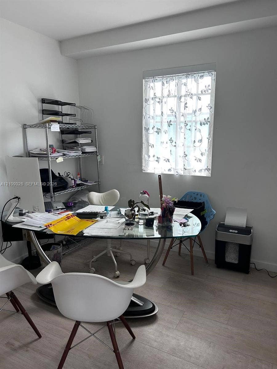 Neutral-toned room featuring wood-finish flooring and a window providing natural light