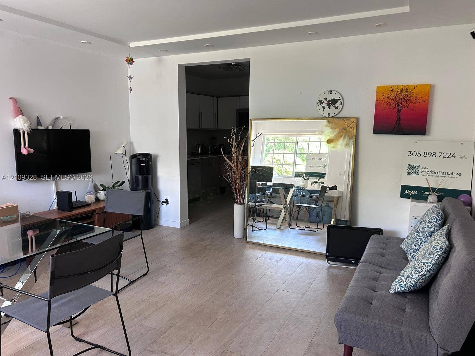 Living area featuring wood-finish flooring, recessed ceiling lighting, and a multi-pane exterior window