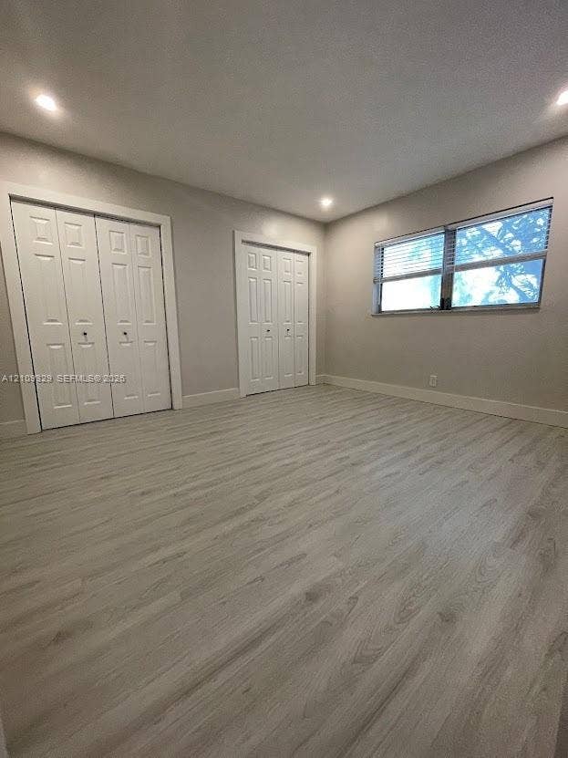 2418 Polk Street, #205, Hollywood, Hollywood, FL 33020 Light-filled interior featuring wood-finish flooring, recessed lighting, and two double-door closets