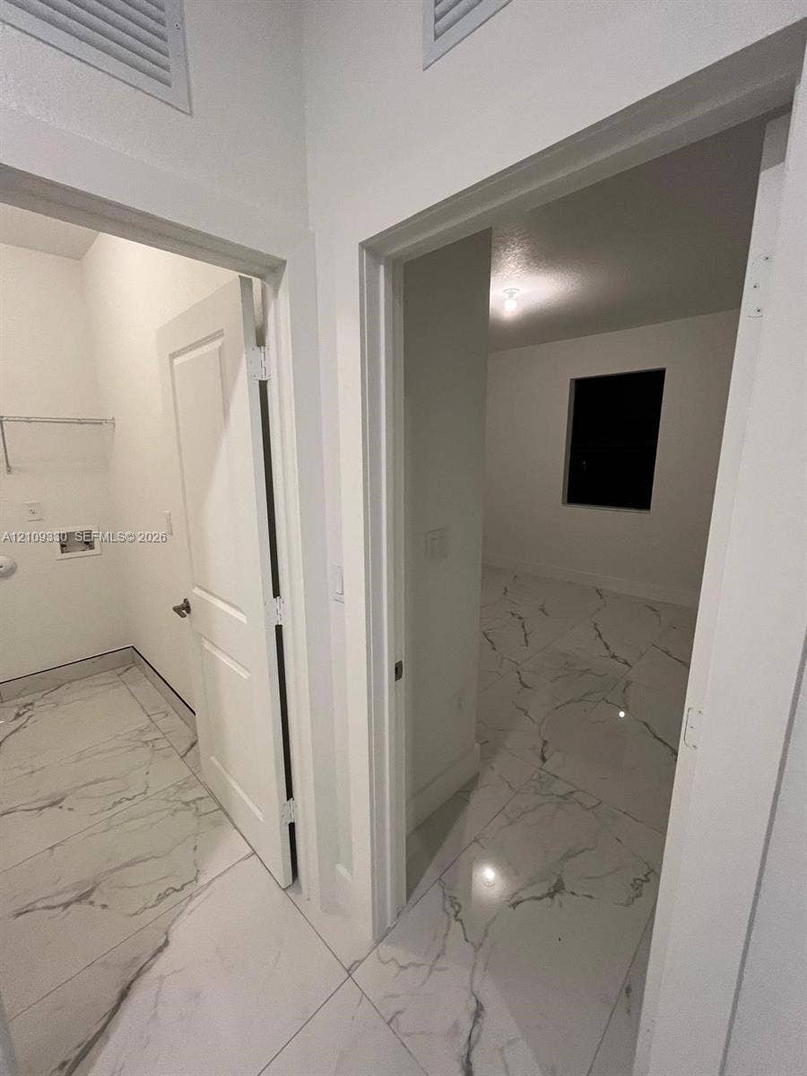 Large-format stone-look tile flooring, solid-core interior doors, and dedicated laundry utility connections