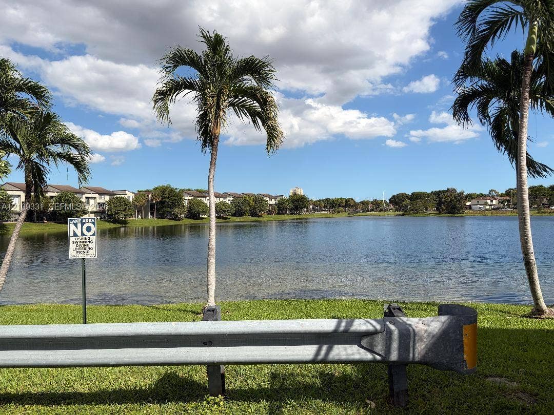 10231 Fontainebleau Boulevard, #106, Miami, FL 33172 Waterfront landscape featuring mature palm trees and manicured grass grounds