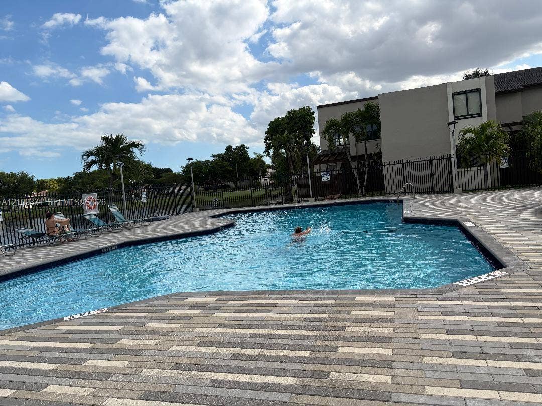 10231 Fontainebleau Boulevard, #106, Miami, FL 33172 In-ground swimming pool featuring a multi-tone paver deck and metal perimeter fencing
