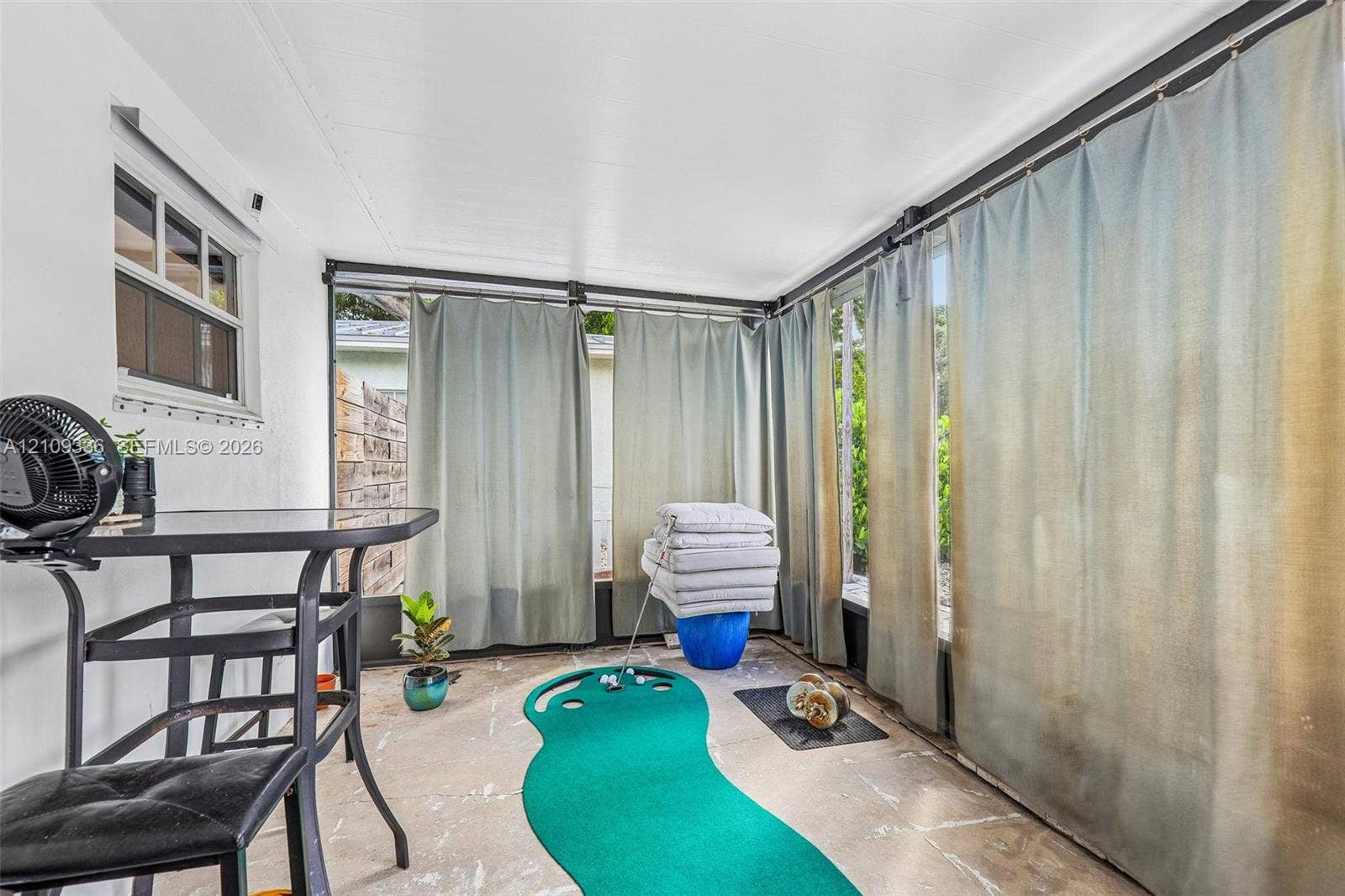 Enclosed sunroom featuring concrete flooring, multi-pane window, and surrounding screen panels