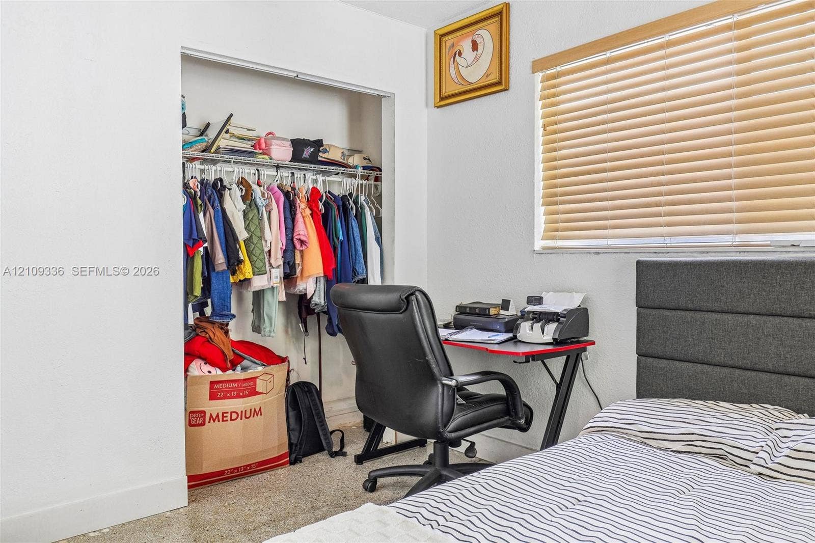Interior space featuring a built-in reach-in closet with wire shelving and horizontal slat window blinds
